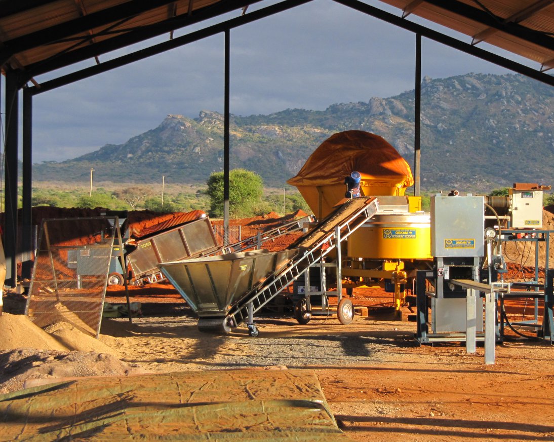 Een Compressed Earth Block Machine met 6 transportbanden, maalmachine, sproei doseersysteem en mobiele menger